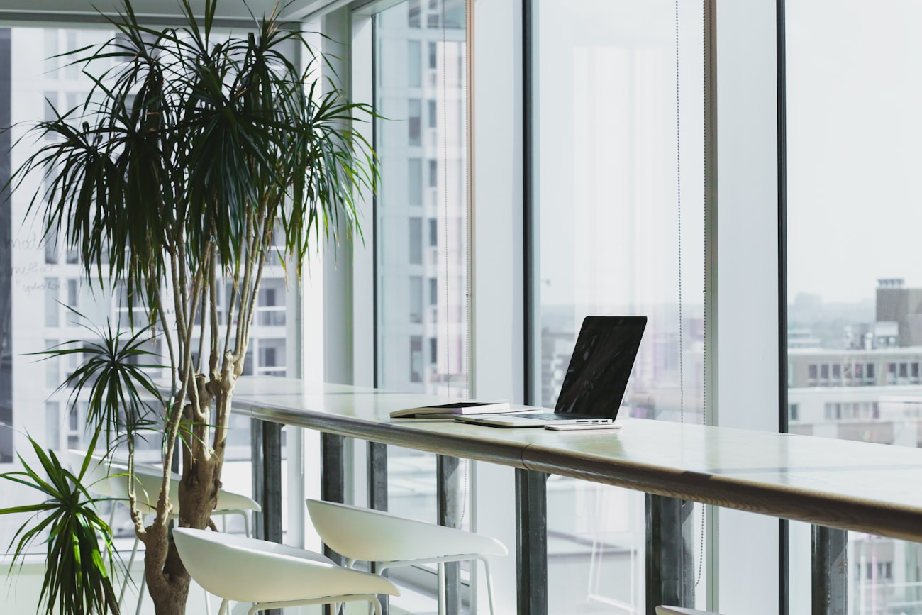 Bright modern Singapore office workspace with a laptop and city view